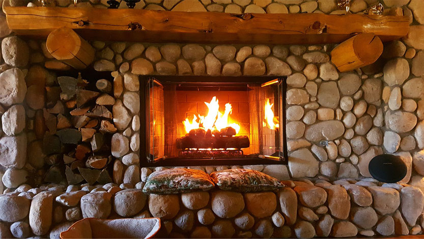 Fireplace lit and fed by seasoned firewood.